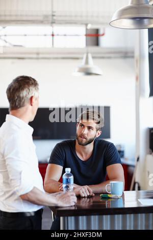 Business during their break. Shot of two handsome businessmen having a discussion in the office. Stock Photo