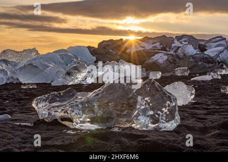 sun shining through ice at Diamond Beach, Breidamerkursandur, southeast Iceland Stock Photo