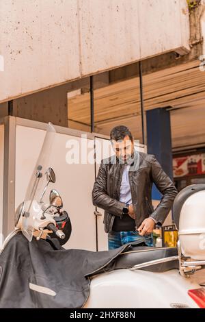 Senior and handsome businessman is preparing to ride his motorbike alone, on a sunny day Stock Photo