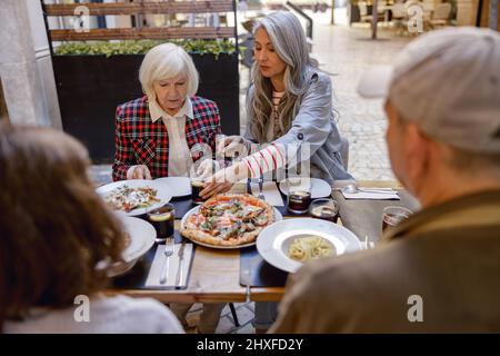 Female friends having conversation at street cafe Stock Photo