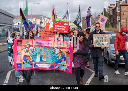 Glasgow, Scotland, UK. 12th March, 2022. Campaigners join the Women's March For Equality from Govanhill Park to Queens Park as part of International Women's Day celebrations. Credit: Skully/Alamy Live News Stock Photo