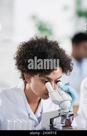 female scientist looking through a microscope. close-up. Stock Photo
