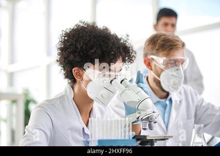 woman in protective clothing examining samples in the laboratory. Stock Photo