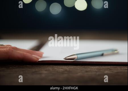 Low angle view of a pen lying on document, contract or application form in a folder. Stock Photo
