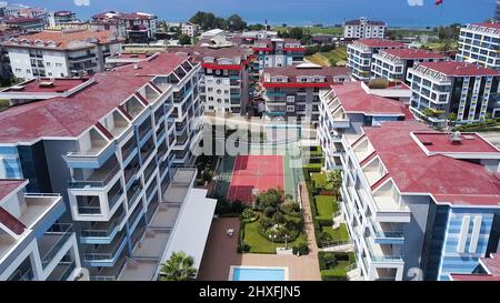 View from the resort area from a drone. Clip. Clear blue sea with huge houses and recreation areas mountains are visible in the background. Stock Photo