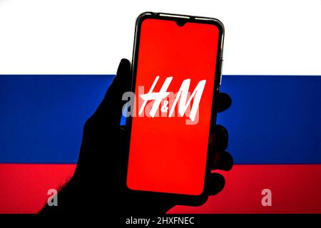 Barcelona, Catalonia. 11th Mar, 2022. In this photo illustration a H&M logo seen displayed on a smartphone with a flag of the Russia in the background. (Credit Image: © Thiago Prudencio/DAX via ZUMA Press Wire) Stock Photo