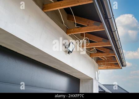 The light for the motion sensor mounted on the facade of the building above the garage door in anthracite color. Stock Photo