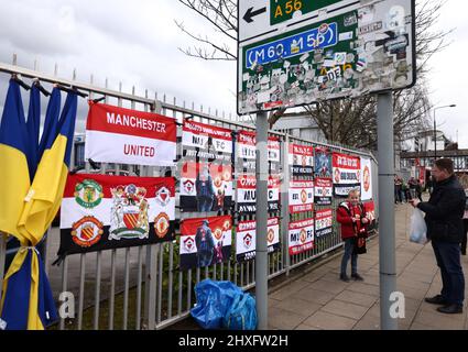 Manchester, England, 12th March 2022.  A Manchester United fan stands in front of banners before the Premier League match at Old Trafford, Manchester. Picture credit should read: Darren Staples / Sportimage Credit: Sportimage/Alamy Live News Stock Photo