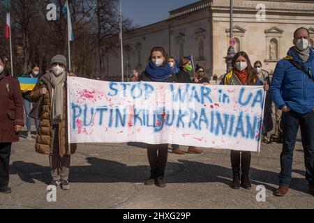 Participants with banner „Stop war in UA, Putin kills Ukrainians“. On March 12, 2022, hundreds of people gathered at the Koenigsplatz in Munich, Germany, to show their solidarity with Ukraine. The demonstrators demanded the immediate withdrawal of Russian troops, a political solution to the conflict, the support of the German government and immediate sanctions against Russia. (Photo by Alexander Pohl/Sipa USA) Stock Photo