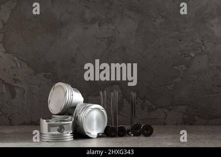 Set of new car pistons and valves on concrete gray background, car repair parts, copy space Stock Photo