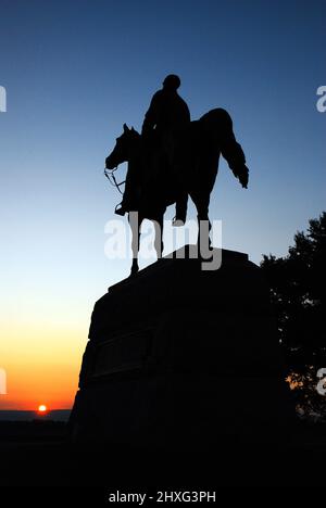 A memorial to General Meade stands in silhouette at sunset on the Gettysburg National Battlefield Stock Photo