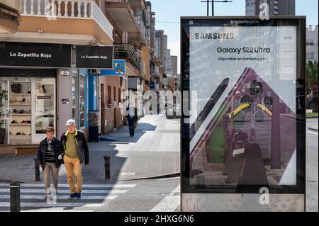 Alicante, Spain. 11th Mar, 2022. Pedestrians walk past a street commercial ad of the South Korean multinational electronics conglomerate Samsung advertising the Samsung S22 in Spain. (Photo by Xavi Lopez/SOPA Images/Sipa USA) Credit: Sipa USA/Alamy Live News Stock Photo