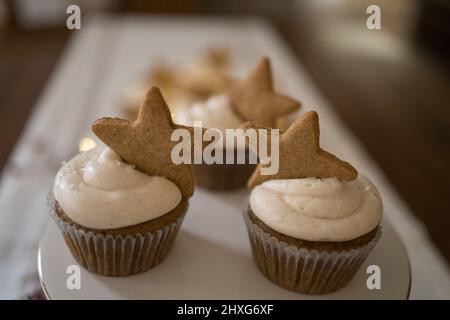 Cupcakes with gingerbread star cookie on white ceramic stand Stock Photo