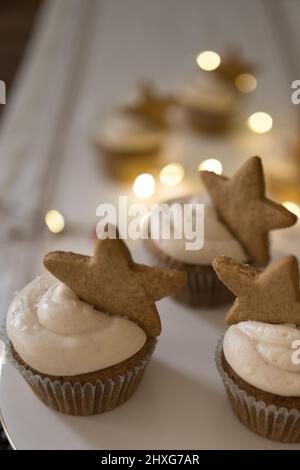 cupcakes with star cookie on white tablecloth with lights Stock Photo
