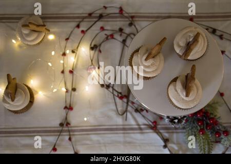 five cupcakes, star cookie on cake stand with lights and berry decoration Stock Photo