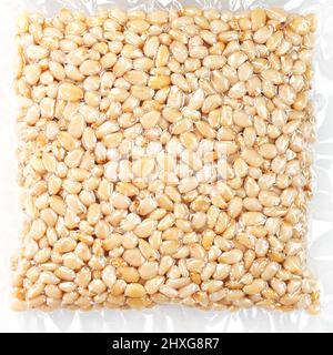 Peeled pine nuts in vacuum packaging on a white background with a free space close-up Stock Photo