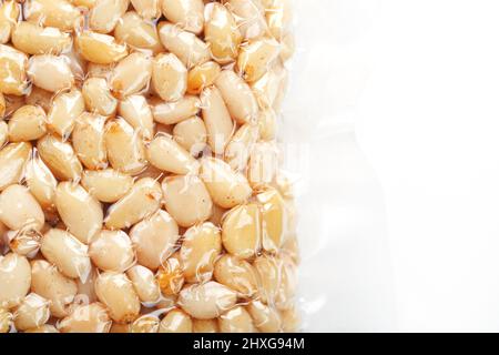 Pine nuts in a transparent vacuum package over a white background Stock Photo