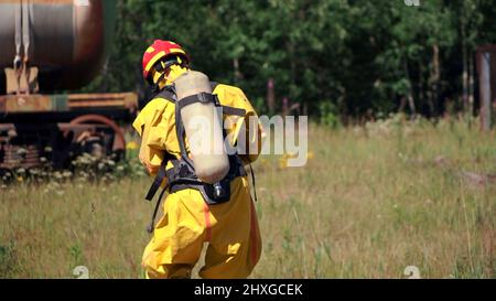 A sign warning of danger. Clip. People performing work in a dangerous area going to a gas mask on the background of a sign warning of danger Stock Photo