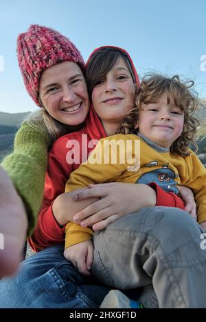 A happy mother making a selfie with her children in nature Stock Photo