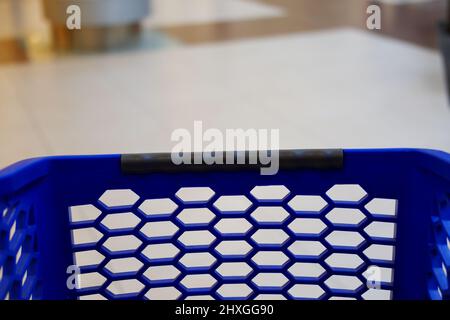 Blue plastic market trolley at mall with blur background Stock Photo