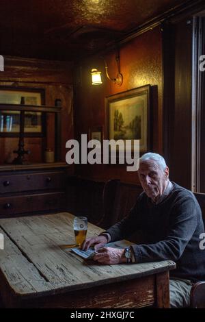 Elderly man drinking pint of lager in pub The White Horse Inn - aka Nellies, Beverly ,Yorkshire,United Kingdom. Stock Photo