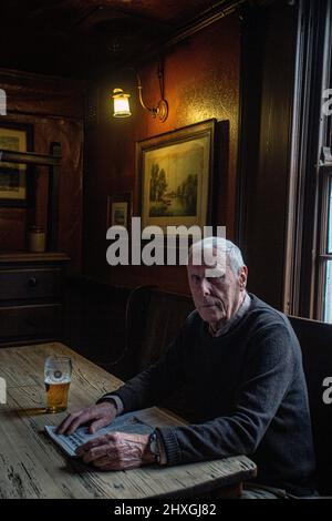 Elderly man drinking pint of lager in pub The White Horse Inn - aka Nellies, Beverly ,Yorkshire,United Kingdom. Stock Photo