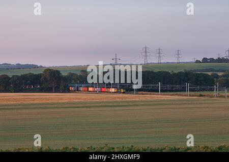 A Freightliner class 70 locomotive passing Cholsey (east of Didcot) on the Great Western mainline with an intermodal container freight rain Stock Photo