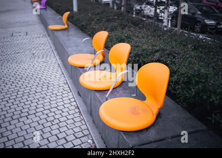 Close-up of three chairs on the walkway in the street Stock Photo