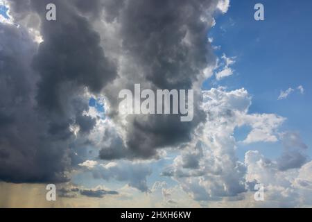 White fluffy cumulus clouds flying, blue sky at fast moving cloud Stock Photo