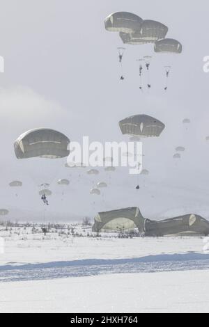 Paratroopers from the 1st Battalion, 501st Parachute Infantry Regiment, part of 4th Brigade, 25th Infantry Division assigned to United States Army Alaska, conduct a Joint Forcible Entry Operation onto Donnelly Drop Zone near Fort Greely, AK March 11, 2022 as part of Joint Pacific Multinational Readiness Center 22-02. JPMRC 22-02, executed in Alaska with its world-class training facilities and its harsh Arctic environment, builds Soldiers and leaders into a team of skilled, tough, alert, and adaptive warriors capable of fighting and winning anywhere. (Staff Sgt. Christopher B. Dennis/USARAK Pub Stock Photo