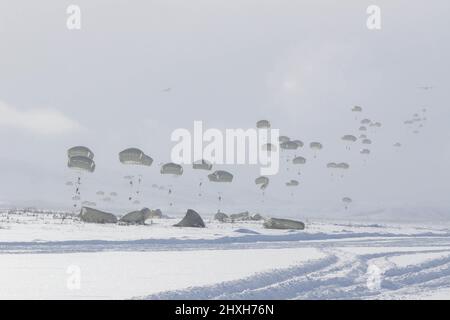 Paratroopers from the 1st Battalion, 501st Parachute Infantry Regiment, part of 4th Brigade, 25th Infantry Division assigned to United States Army Alaska, conduct a Joint Forcible Entry Operation onto Donnelly Drop Zone near Fort Greely, AK March 11, 2022 as part of Joint Pacific Multinational Readiness Center 22-02. JPMRC 22-02, executed in Alaska with its world-class training facilities and its harsh Arctic environment, builds Soldiers and leaders into a team of skilled, tough, alert, and adaptive warriors capable of fighting and winning anywhere. (Staff Sgt. Christopher B. Dennis/USARAK Pub Stock Photo