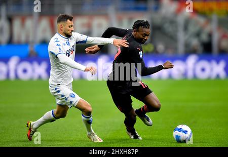 Milan, Italy. 12th Mar, 2022. AC Milan's Rafael Leao (R) vies with Empoli's Nedim Bajrami during a Serie A football match between AC Milan and Empoli in Milan, Italy, on March 12, 2022. Credit: Alberto Lingria/Xinhua/Alamy Live News