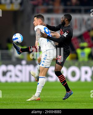 Milan, Italy. 12th Mar, 2022. AC Milan's Fikayo Tomori (R) vies with Empoli's Andrea Pinamonti during a Serie A football match between AC Milan and Empoli in Milan, Italy, on March 12, 2022. Credit: Alberto Lingria/Xinhua/Alamy Live News