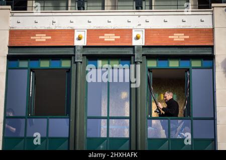 Picture of a male glazier, installing a window in an apartment, residential, working on its multicolor craft glass, in the city center of Arcachon, Fr Stock Photo