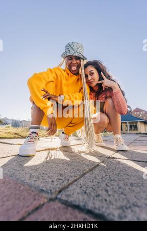 Young female friends posing for the camera. Two female best friends friends having fun together outdoors in the city. Happy female youngsters feeling Stock Photo
