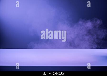 White podium table with smoke over it in the dark Stock Photo
