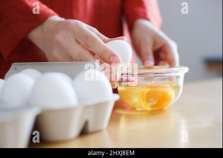 Preparing food, hands cracking up a raw egg. Stock Photo