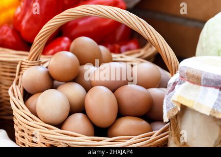 Lots of eggs in a wicker basket at a village fair. Rural food and agriculture concept. Stock Photo