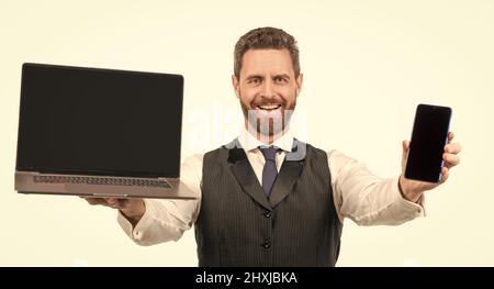 happy man presenting laptop and smartphone isolated on white background, modern life Stock Photo