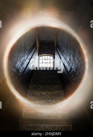 Dark and creepy window open at top of old stone stairs bright sun light rays shining through on floor making shadows and scary sinister abandoned base Stock Photo