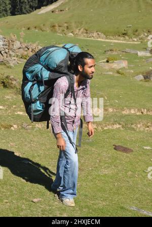 Full length of a young male traveler walking on mountain with carrying parachute backpack Stock Photo