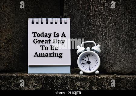 Motivational and inspirational quote on notepad - Today is a great day to be amazing. With rock and alarm clock background. Motivational concept Stock Photo