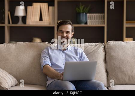 Portrait smiling young man freelancer working on laptop from home Stock Photo