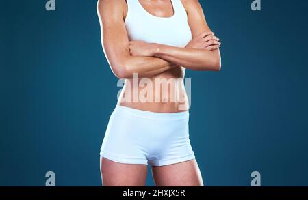 Dont give up on your body goals. Studio shot of an unrecognizable fit woman posing against a blue background. Stock Photo