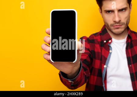 Sad guy holding showing empty smartphone screen Stock Photo