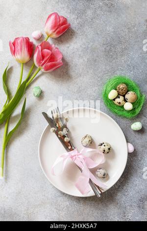 Beautiful table setting with pink tulip flower on light blue background ...
