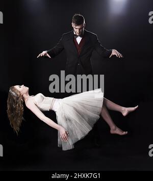 Rise...RISE. Shot of vaudeville magician levitating a woman on stage. Stock Photo