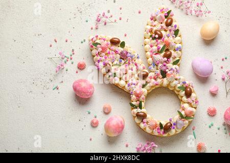 Composition with beautiful cake and painted eggs for Easter celebration on light background Stock Photo