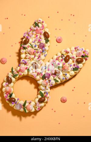 Beautiful cake and meringue for Easter celebration on orange background Stock Photo