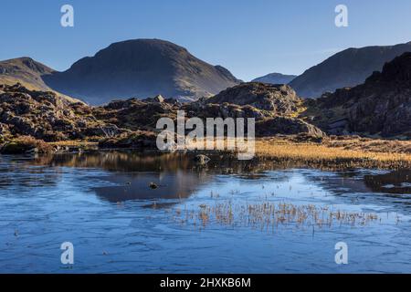 A partially frozen Innominate Tarn in the Buttermere Fells with Great Gable in the background, Lake District, England Stock Photo